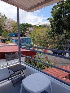 a chair and stool on a balcony with a view at Apartamentos Novoa in San José