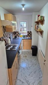 a kitchen with black counter tops and a marble floor at Spacious Central Reading Flat, 2 Double Beds, Wi-Fi, Parking in Reading