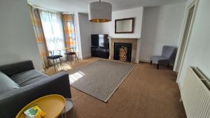 a living room with a couch and a fireplace at Spacious Central Reading Flat, 2 Double Beds, Wi-Fi, Parking in Reading