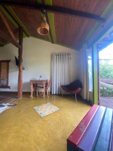 a living room with a table and a chair at Chalé Bougainville in Lavras Novas