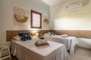a room with two beds and a window at Refúgio Gostoso in São Miguel do Gostoso