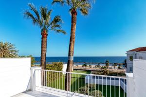 ein Balkon mit Palmen und Meerblick in der Unterkunft Miramare Luxury Dependance in Sanremo
