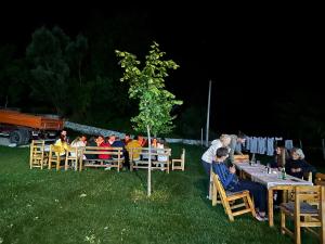 a group of people sitting at tables at night at Bujtina Vellezerit Grrela in Theth