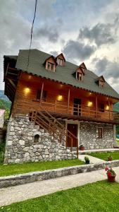 a large wooden house with a stone at Bujtina Vellezerit Grrela in Theth