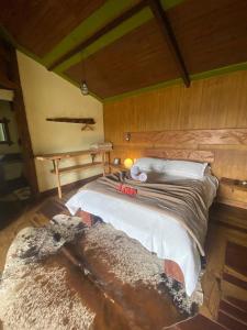 a bedroom with a large bed in a room at Chalé Bougainville in Lavras Novas