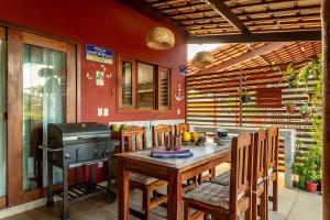 a kitchen with a table and a grill and chairs at Refúgio Gostoso in São Miguel do Gostoso