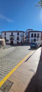 a street with buildings and a car on the road at MariaValiente in Montoro