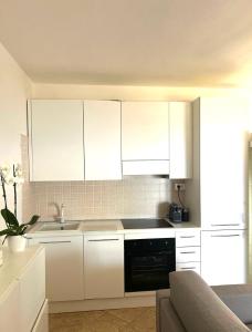a kitchen with white cabinets and a sink and a couch at Casa il Bouganville - sea view Costa Paradiso in Costa Paradiso +42 photos