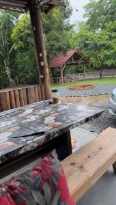 a picnic table and a bench in a park at Rancho300 - Quiriri - Joinville in Joinville