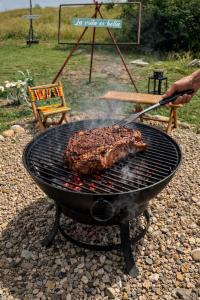 a person is cooking meat on a grill at Green Valley a 5 min de Xielo Paracaidismo,la pista secreta y Paintball rural Leticia in Ricaurte