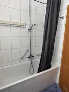 a shower with a black shower curtain in a bathroom at Ferienwohnung Fehmarn am Südstrand in Fehmarn +8 photos