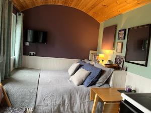 a bedroom with a bed and a table and a television at The Aultnamain Shepherds Hut in Wester Fearn