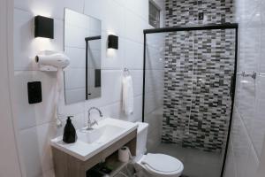 a white bathroom with a toilet and a sink at VILLA BILAC - Large Studios close to Vila Germânica in Blumenau +61 photos