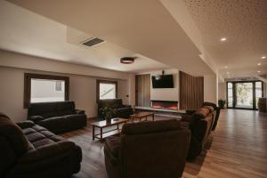 a living room with couches and a flat screen tv at La Trobada Hotel Sport in Ripoll