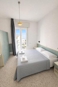 ein Schlafzimmer mit einem großen Bett und einem großen Fenster in der Unterkunft Hotel Zamagna in Cesenatico