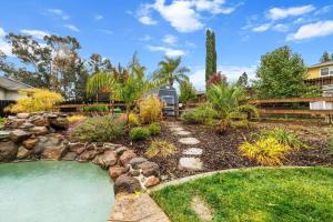 a backyard with a pond and a landscaping with rocks at Tranquil Retreat: Pool, Spa, Firepit, Peloton, WFH in Orangevale