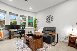 an office with a couch and a desk with a computer at Tranquil Retreat: Pool, Spa, Firepit, Peloton, WFH in Orangevale