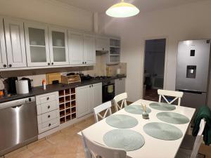 a kitchen with a table and chairs in a kitchen at 7Csakra Vendeghaz in Szentendre