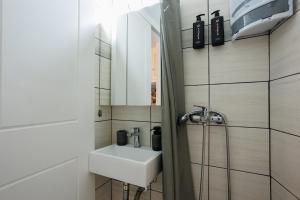 a white bathroom with a sink and a shower at Corfu Bay Serenity Suite in Ágios Rókkos