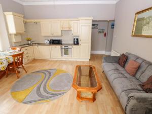 a living room with a couch and a table at 1 Hilton Flats in Tenby +13 photos