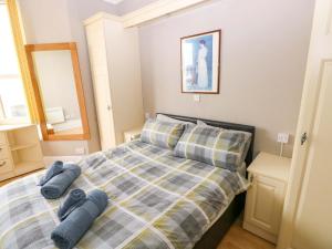 a bedroom with a bed with blue pillows on it at 1 Hilton Flats in Tenby