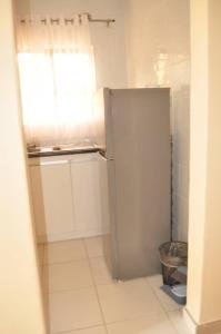 a small kitchen with a refrigerator in a room at RosiMug's Homestay in Umtali +5 photos