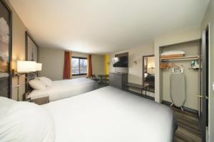 a hotel room with two beds and a television at Super 8 by Wyndham Kingston in Kingston