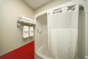 a bathroom with a shower with a white shower curtain at Super 8 by Wyndham Kingston in Kingston +59 photos