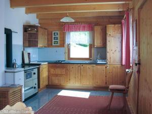 a kitchen with wooden cabinets and a window at Almhütte Tschiernock in Seeboden
