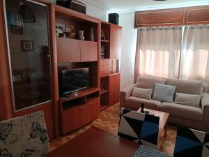 a living room with a couch and a flat screen tv at A Ribeira in Fene
