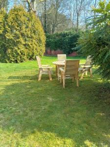 a group of benches and a picnic table in the grass at 2 Bedroom Garden Flat in Halesworth