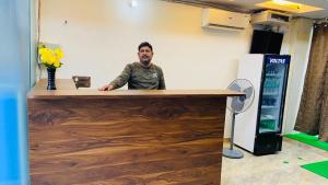 a man standing behind a wooden counter in a room at hotel shad residency in Bankipur