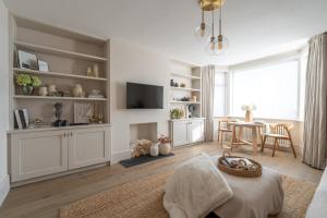 a living room with a television and a table at Blu's Seaview Apartment in Rhos-on-Sea