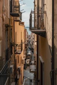 an alleyway between buildings with balconies in a city at Dimora Costa Cefalù in Cefalù