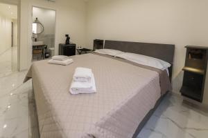 a bedroom with a bed with towels on it at Dimora Costa Cefalù in Cefalù