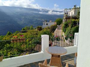 a table and chairs on a balcony with a view at La Locana in Bubión