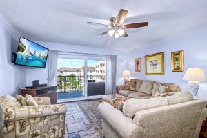a living room with a couch and a ceiling fan at Reef Club 304 in Clearwater Beach