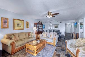 a living room with two couches and a ceiling fan at Reef Club 304 in Clearwater Beach