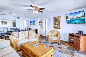 a living room with a couch and a table at Reef Club 304 in Clearwater Beach +49 photos