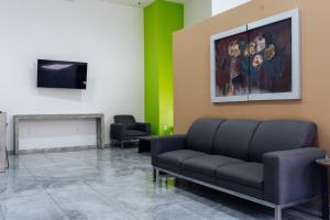 ein Wartezimmer mit einer Couch und einem Gemälde an der Wand in der Unterkunft SR Hotel in Guadalajara