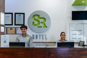 Zwei Männer sitzen mit ihren Laptops an einem Tresen. in der Unterkunft SR Hotel in Guadalajara