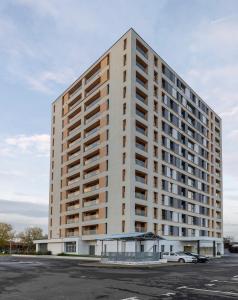 a large white building with a car parked in front at Lila Residence - by Solinis Homes in Bucharest