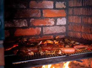 a group of meats cooking in a brick oven at Pensjonat u Bernackich in Smołdzino