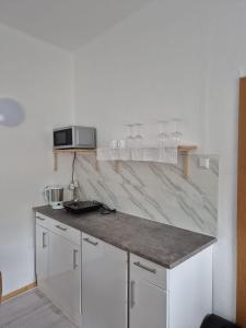 a kitchen with white cabinets and a counter top at Alte Post - Sonne in Gurk