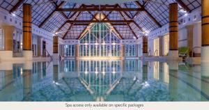 a swimming pool in a building with a glass ceiling at Champneys Forest Mere in Liphook