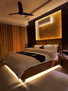 a bedroom with a large bed and a ceiling fan at Go Glam Hotels Bahria Town in Rawalpindi