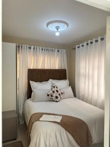 a bedroom with a large bed with white pillows at RosiMug's Homestay in Umtali