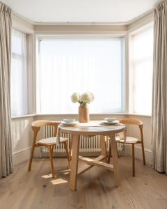a dining room table and chairs in front of a window at Blu's Seaview Apartment in Rhos-on-Sea +3 photos