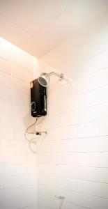 a shower in a white tiled bathroom at EAIN-WORKplusSTAY in Bangkok
