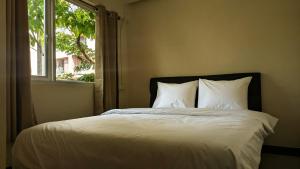 a bed with white sheets in a room with a window at EAIN-WORKplusSTAY in Bangkok +25 photos